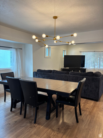 545 23rd Street Ogden, UT 84401 - Photo 23 of 28 Open-concept living space featuring wood-finish flooring, a modern brass chandelier, and white walls