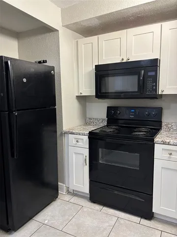 a kitchen with granite countertop a refrigerator and a sink