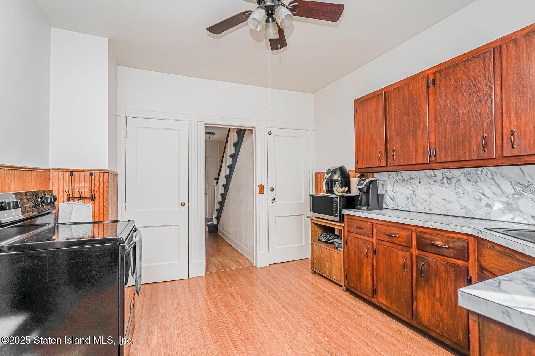 5300 Amboy Road Staten Island, NY 10312 - Photo 8 of 32 a kitchen with stainless steel appliances granite countertop a refrigerator a sink dishwasher a stove and white countertops with wooden floor