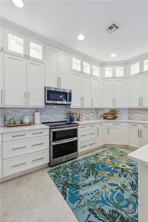 5690 Elbow Avenue Naples, FL 34113 - Photo 11 of 39 a kitchen with kitchen island stainless steel appliances and cabinets