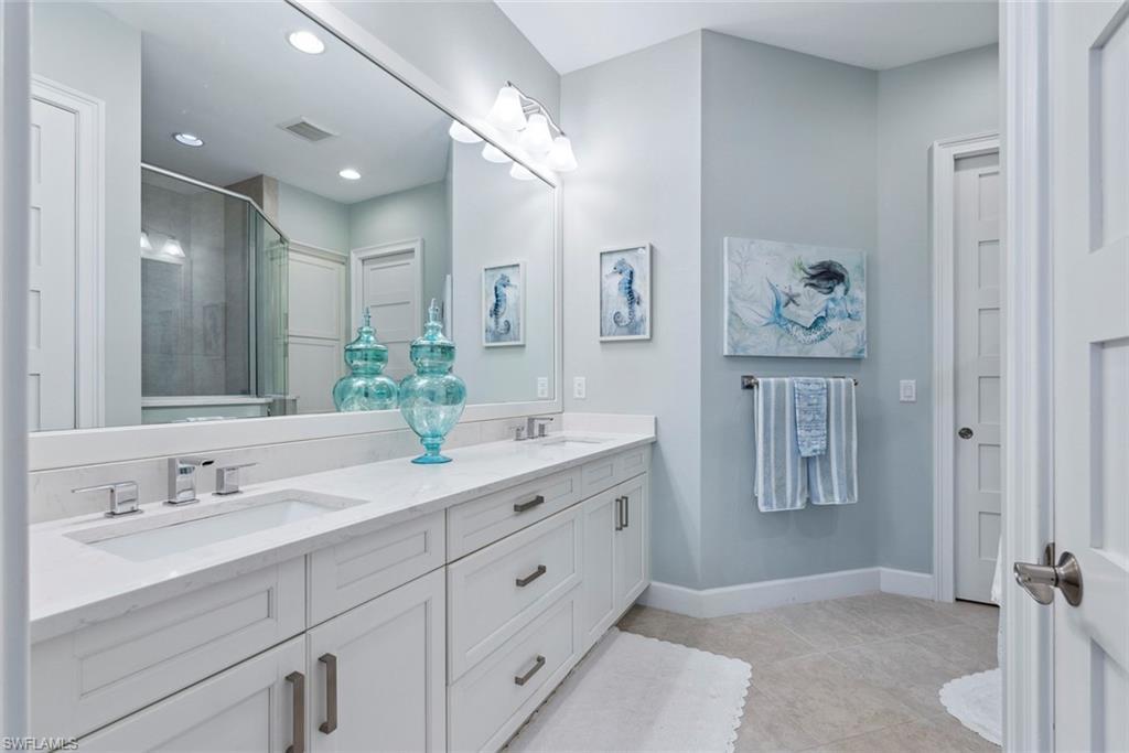 5690 Elbow Avenue Naples, FL 34113 - Photo 14 of 39 a spacious bathroom with double vanity sinks a mirror and a shower