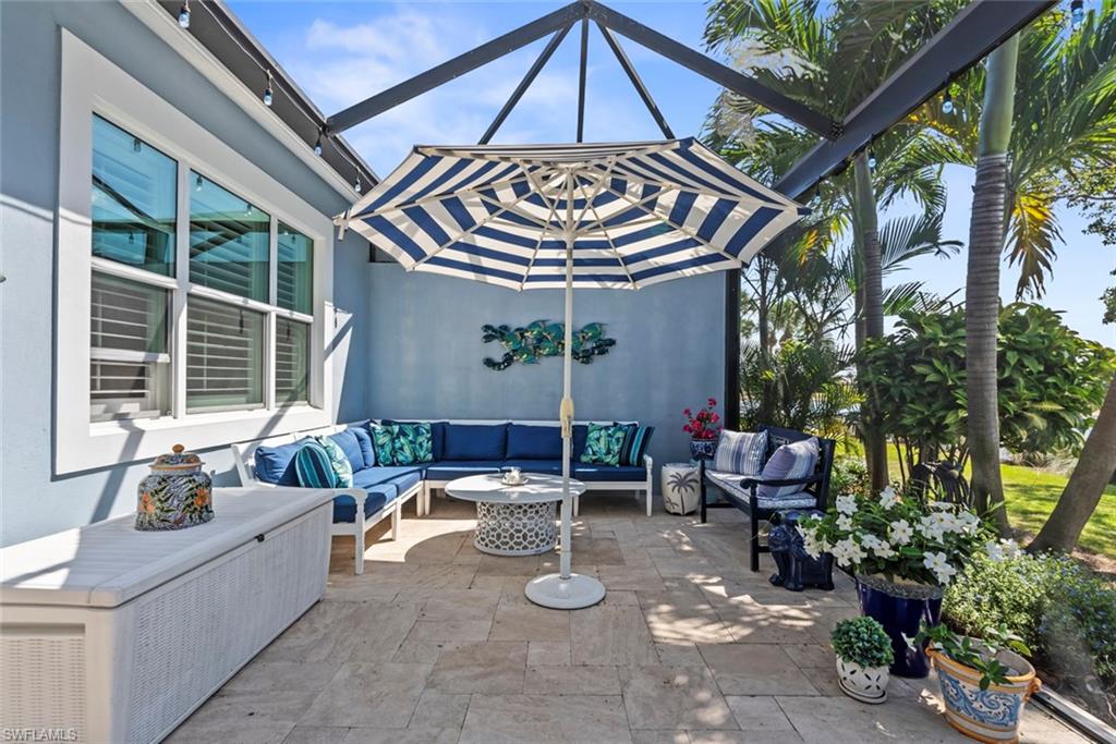 5690 Elbow Avenue Naples, FL 34113 - Photo 22 of 39 a roof deck with table and chairs under an umbrella