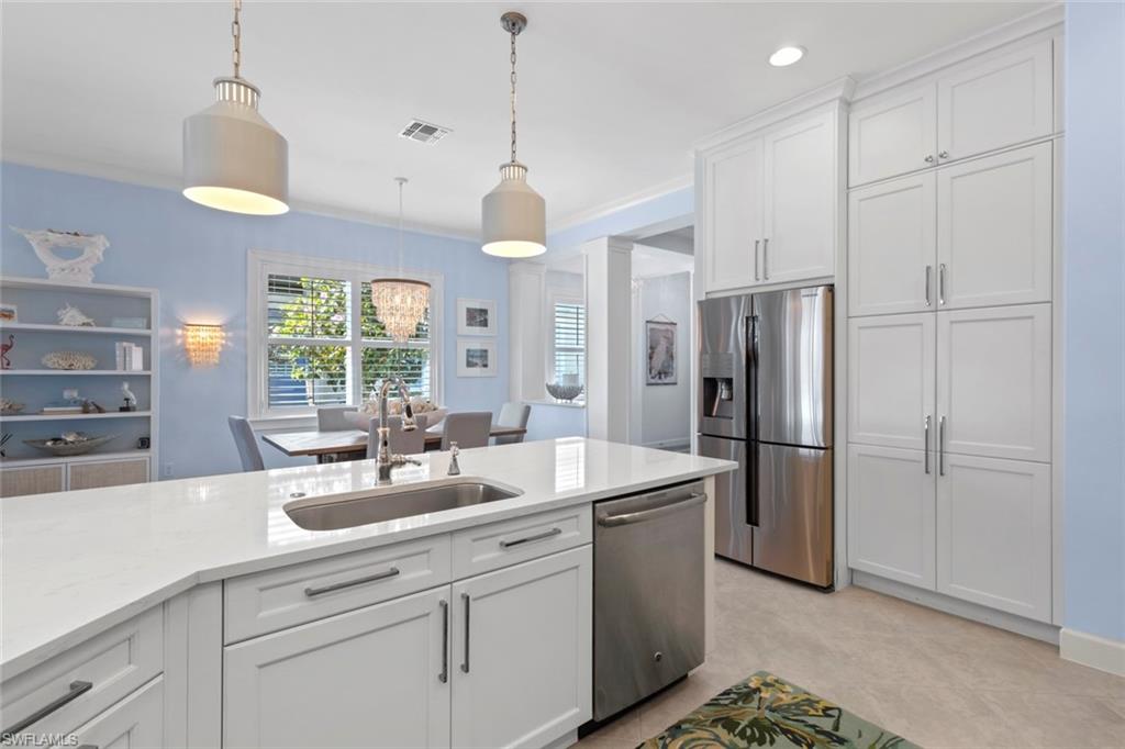 5690 Elbow Avenue Naples, FL 34113 - Photo 10 of 39 a kitchen with stainless steel appliances a refrigerator a sink a center island and windows