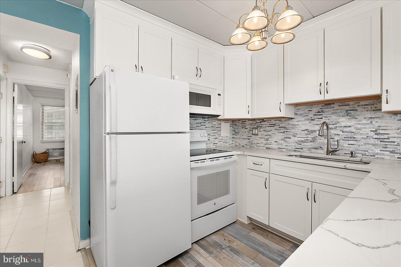 18 69th Street, Unit 9 Ocean City, MD 21842 - Photo 13 of 60 a white kitchen with cabinets and stainless steel appliances