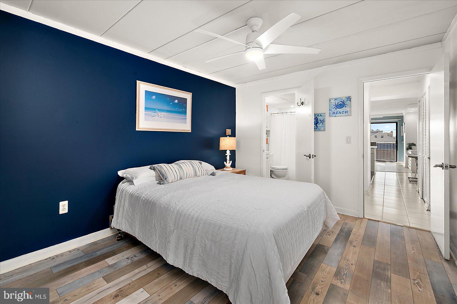 18 69th Street, Unit 9 Ocean City, MD 21842 - Photo 24 of 60 a bedroom with a large bed chandelier and a window