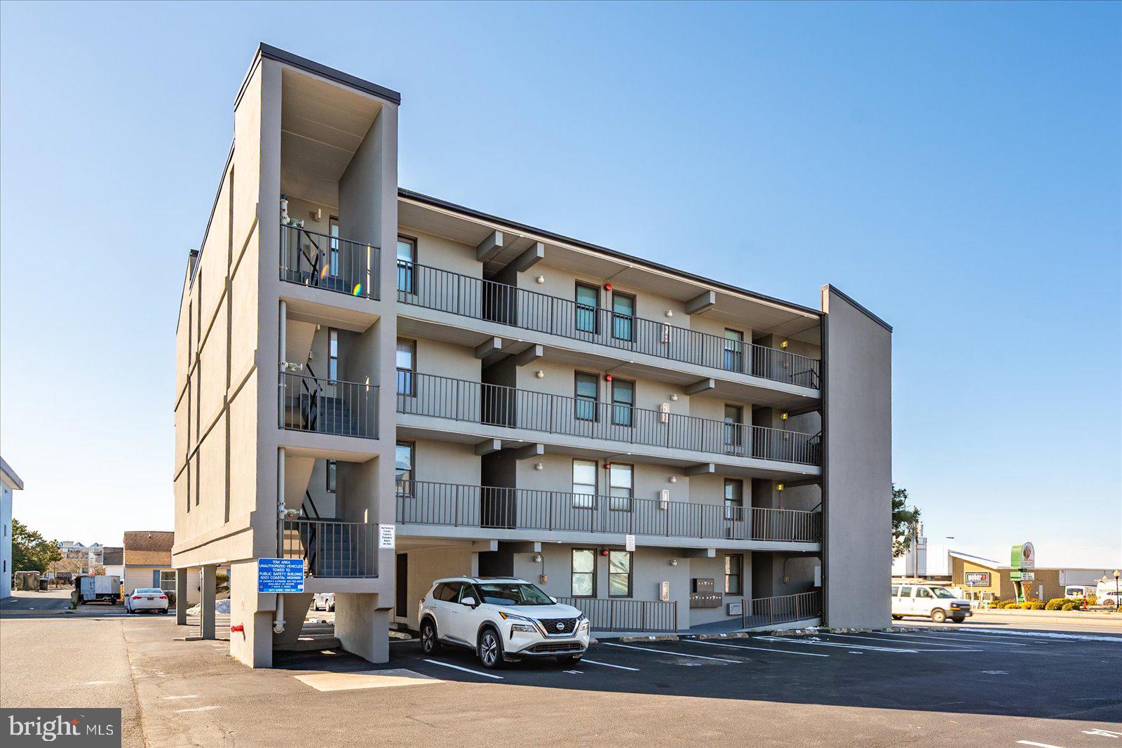 18 69th Street, Unit 9 Ocean City, MD 21842 - Photo 40 of 60 a front view of a building with lot of cars and trees