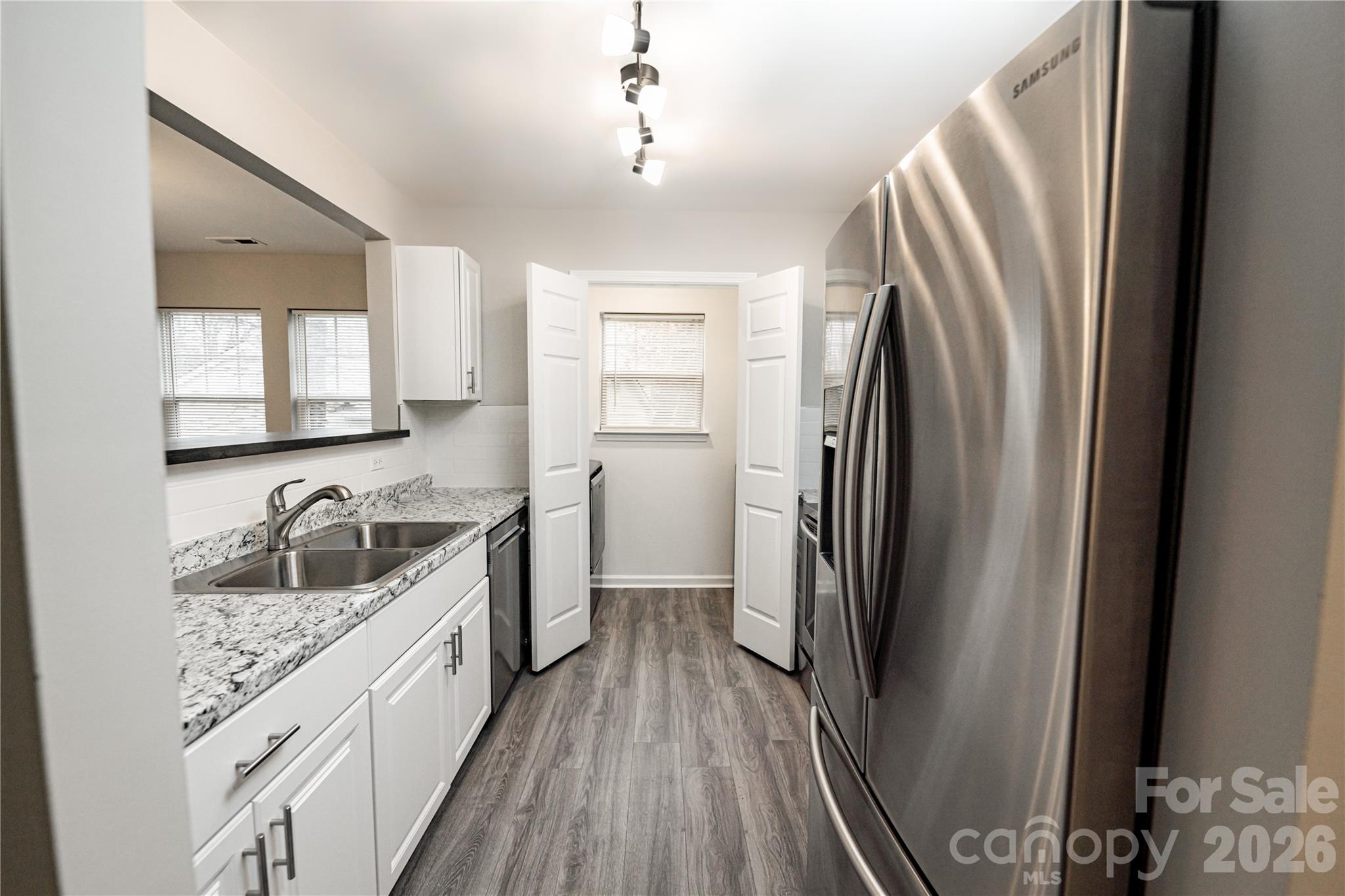 837 Rodey Avenue, Unit 20 Charlotte, NC 28206 - Photo 11 of 12 a kitchen with refrigerator a sink and dishwasher with wooden floor