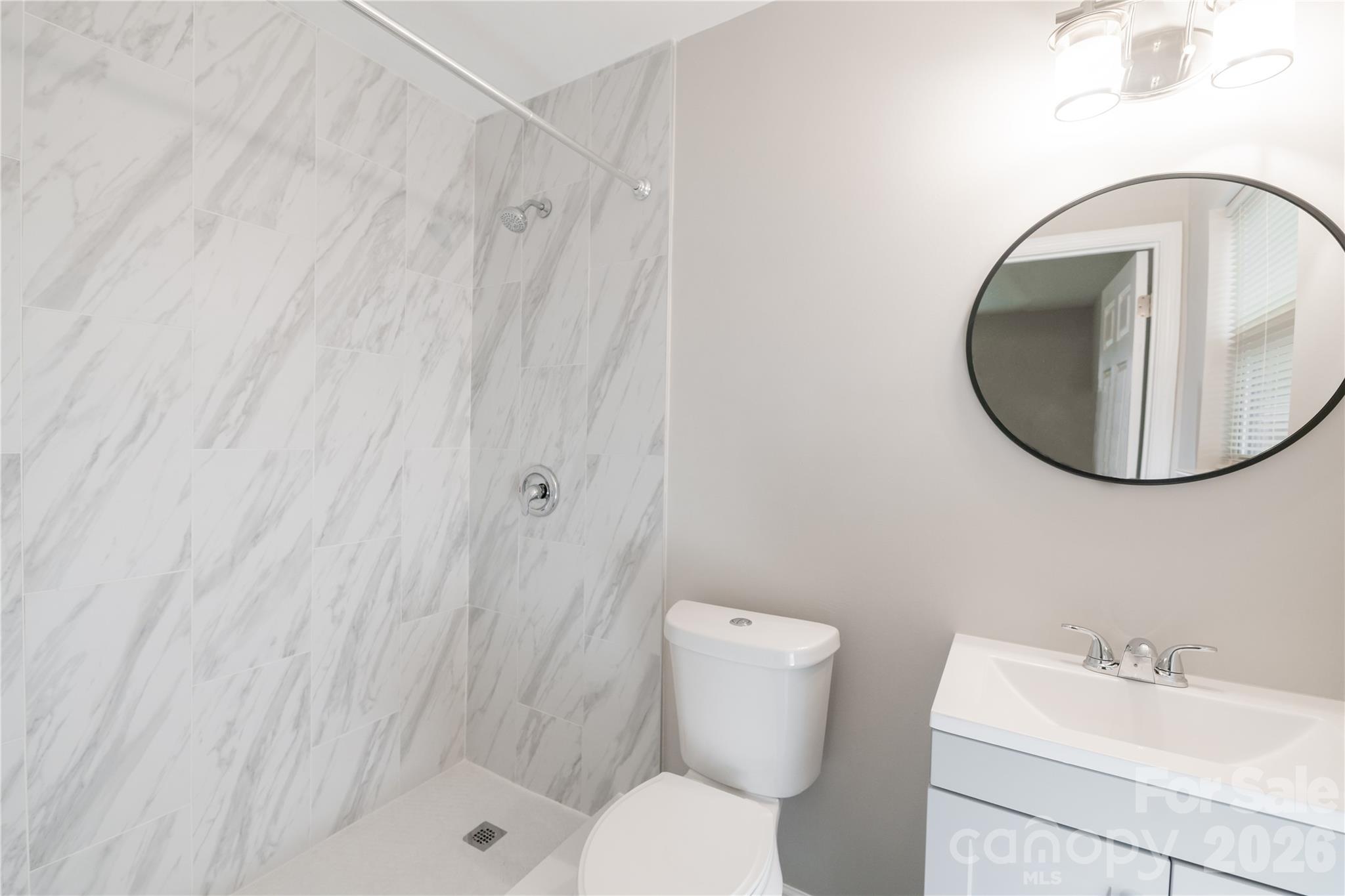 837 Rodey Avenue, Unit 20 Charlotte, NC 28206 - Photo 12 of 12 a bathroom with a toilet sink vanity and mirror