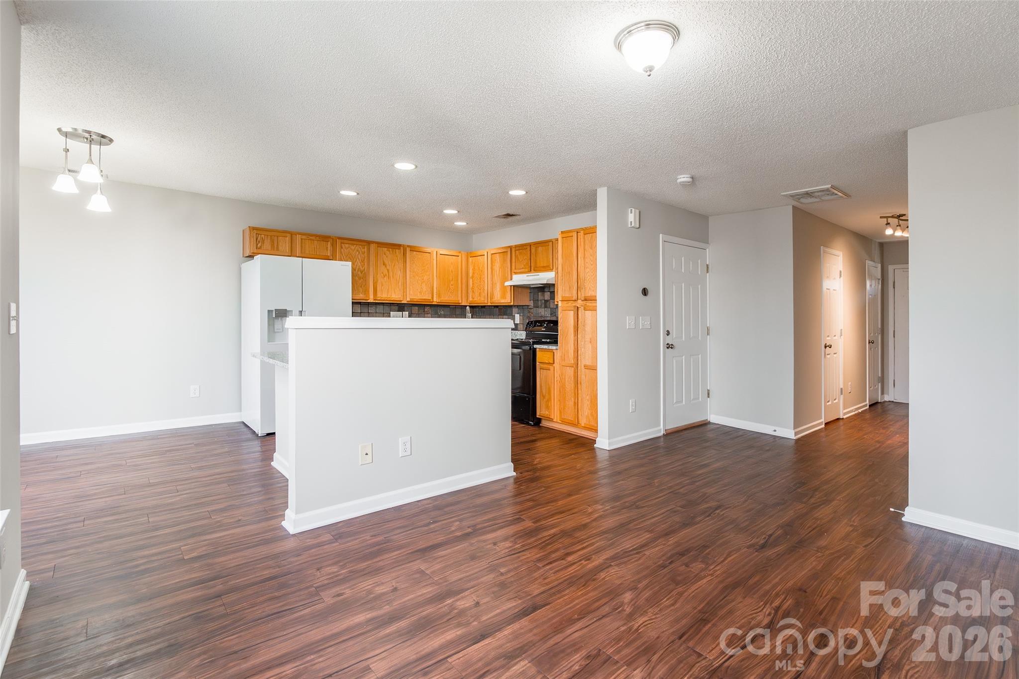 3167 Caldwell Ridge Parkway Charlotte, NC 28213 - Photo 5 of 36 a view of a kitchen with a refrigerator and wooden floor