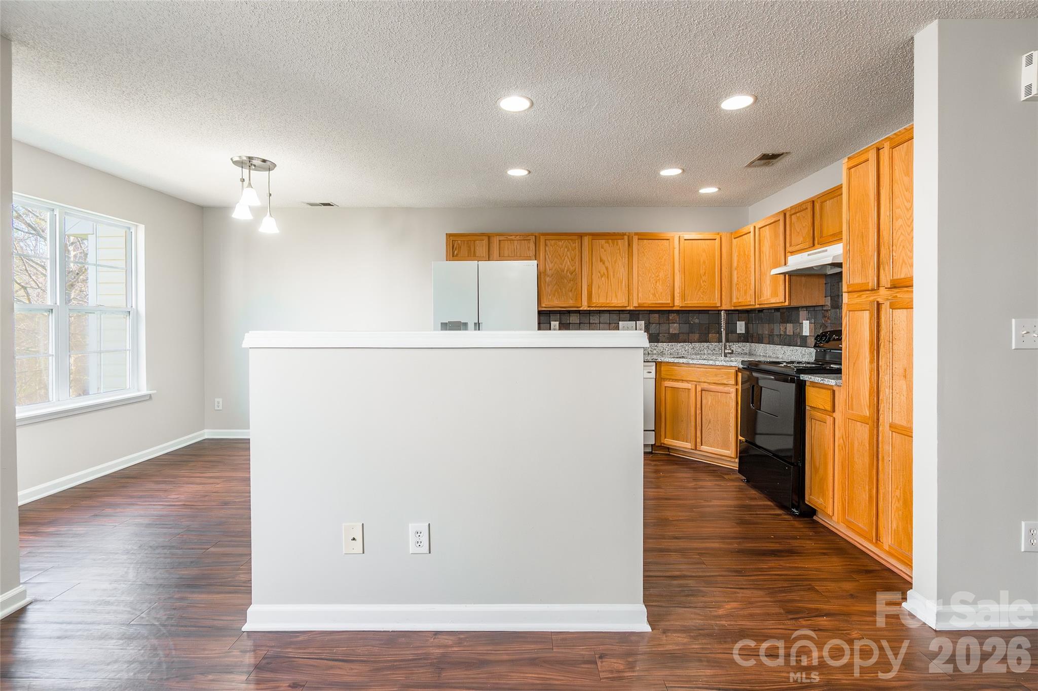 3167 Caldwell Ridge Parkway Charlotte, NC 28213 - Photo 7 of 36 a kitchen with stainless steel appliances granite countertop a refrigerator a sink dishwasher and a stove with wooden floor