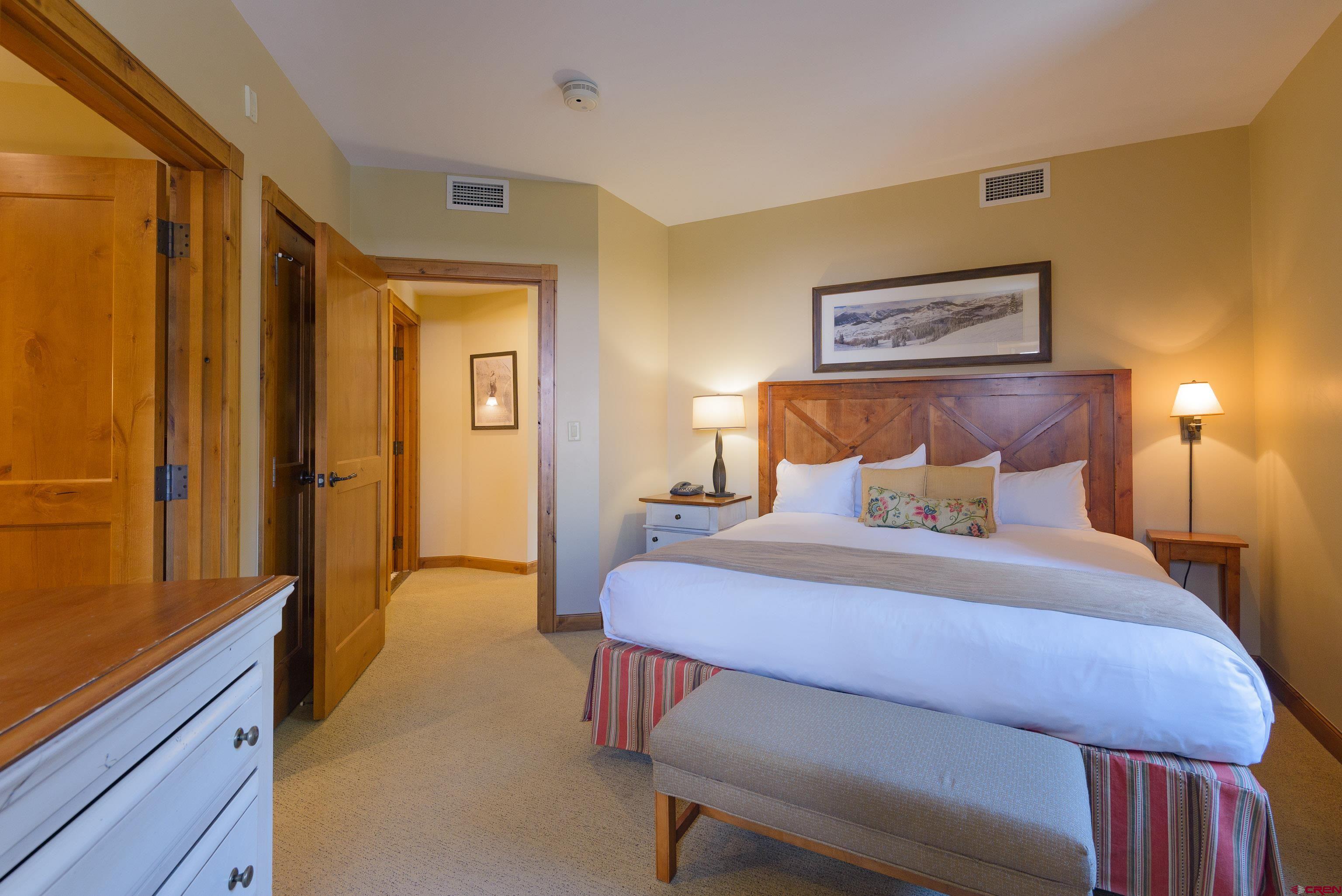 620 Gothic Road, Unit 317 Crested Butte, CO 81225 - Photo 32 of 43 a bedroom with a bed and a dresser with mirror