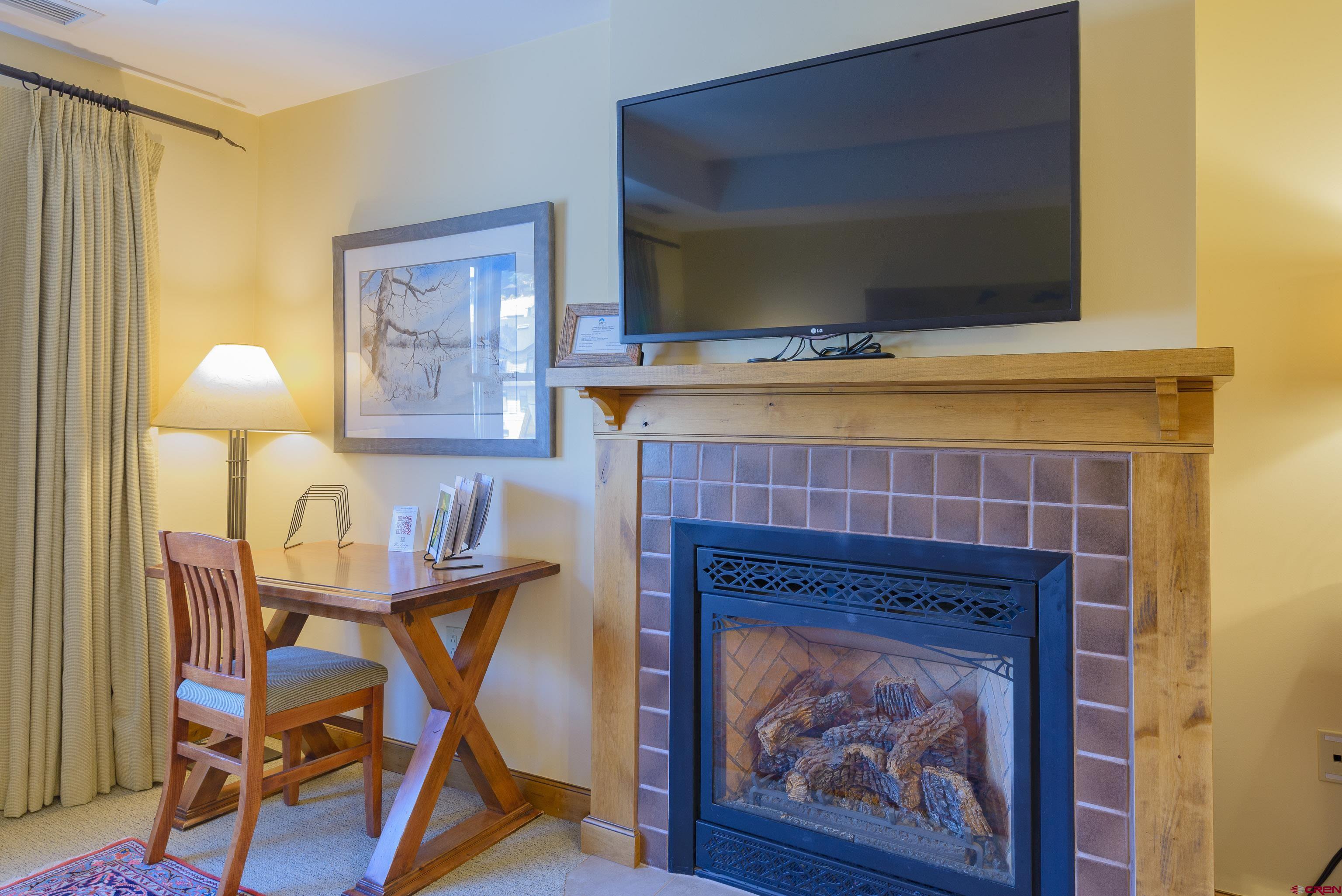 620 Gothic Road, Unit 317 Crested Butte, CO 81225 - Photo 10 of 43 a living room with a fireplace and a flat screen tv