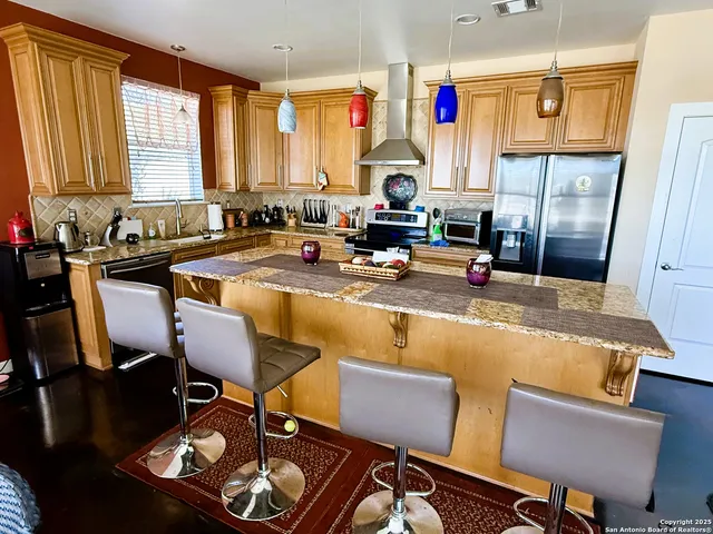 a kitchen with a table chairs stove and refrigerator