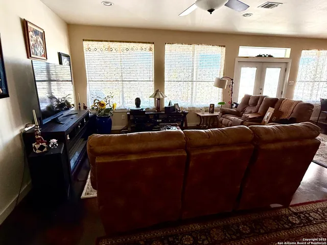 a living room with furniture tv and a window