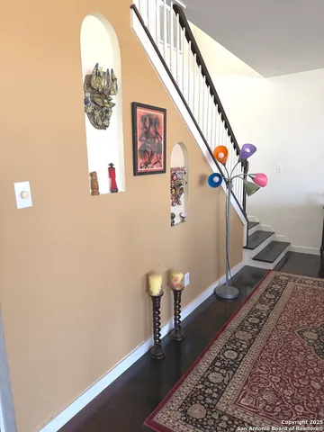 a view of a hallway with wooden floor and stairs