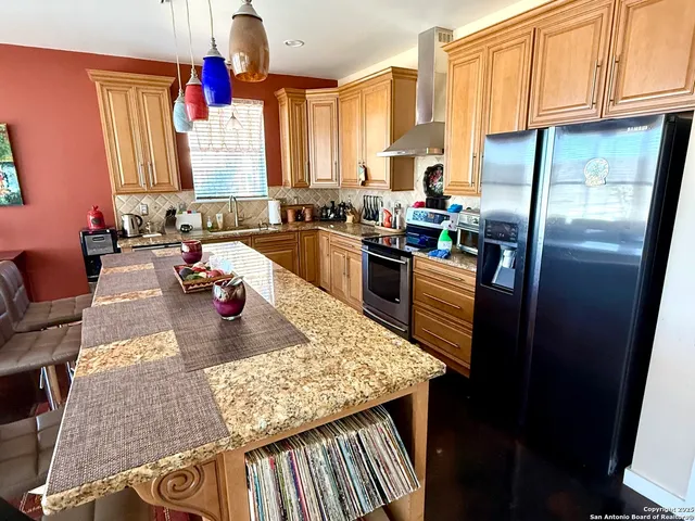 a kitchen with sink refrigerator and cabinets