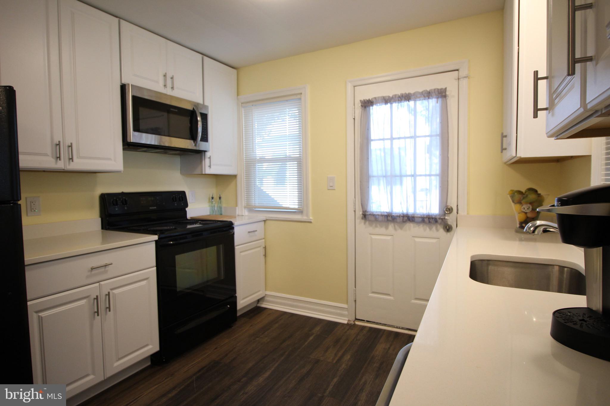 209 Champlain Avenue Wilmington, DE 19804 - Photo 10 of 26 a kitchen with granite countertop a sink wooden floor and a stove top oven