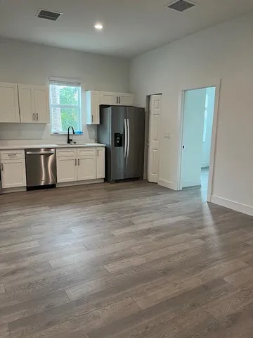 a large kitchen with a refrigerator sink and cabinets
