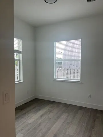 an empty room with wooden floor door and closet
