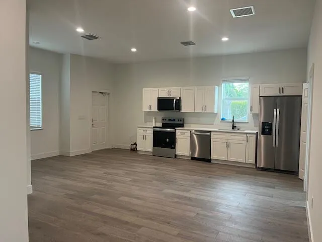 a kitchen with a sink a refrigerator and cabinets