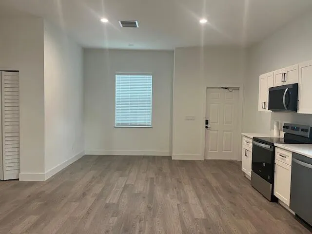 a view of kitchen with wooden floor and electronic appliances