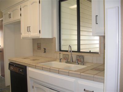 Kitchen, Tile counter tops, beautiful white cabinets, window overlooking the front yard, dishwasher, disposal.