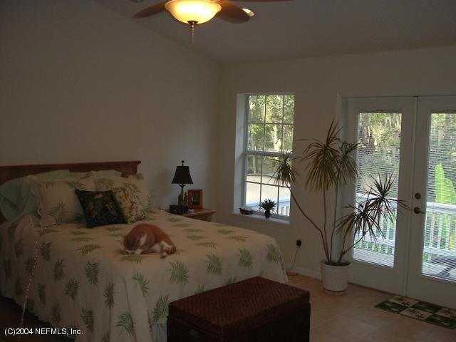 8435 Florence Cove Road St. Augustine, FL 32092 - Photo 13 of 20 a bed sitting in a bedroom next to a window