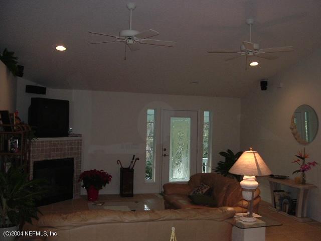 8435 Florence Cove Road St. Augustine, FL 32092 - Photo 7 of 20 a living room with furniture a fireplace and a flat screen tv