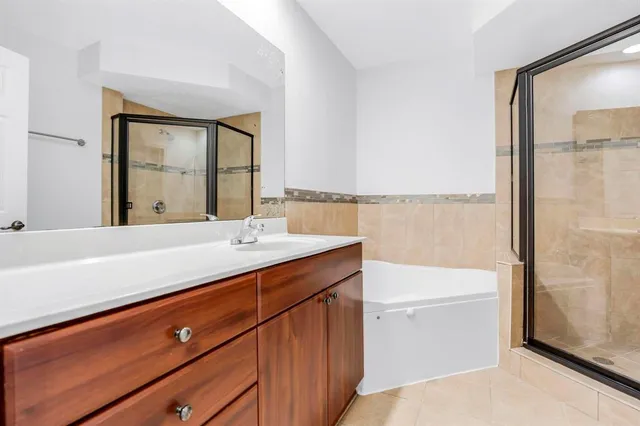 a bathroom with a double vanity sink a mirror and a bathtub