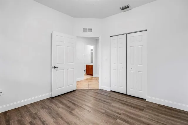a view of a hallway with wooden floor and closet area