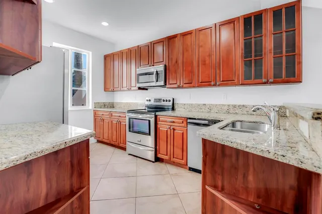 a kitchen with stainless steel appliances granite countertop wooden cabinets a sink and dishwasher