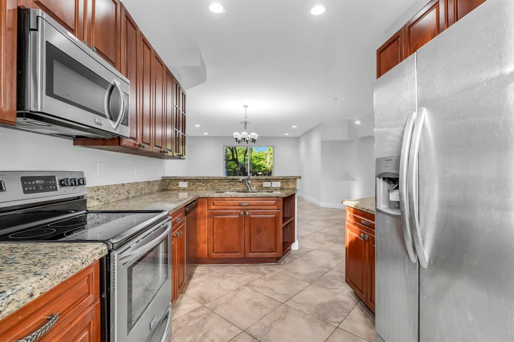 5030 Southwest 126th Avenue, Unit 203 Miramar, FL 33027 - Photo 8 of 41 a kitchen with stainless steel appliances granite countertop a refrigerator a stove and a sink