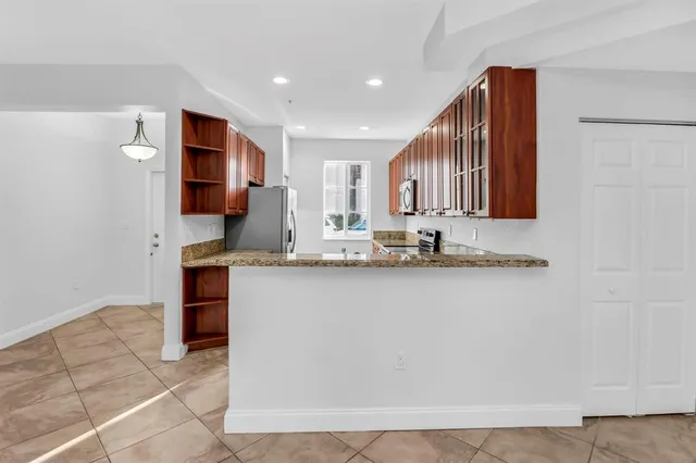 a kitchen with stainless steel appliances granite countertop a sink and a refrigerator
