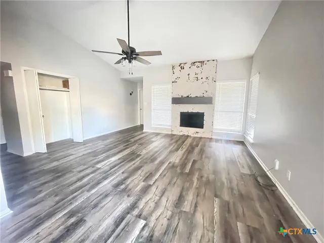wooden floor fireplace and windows in an empty room