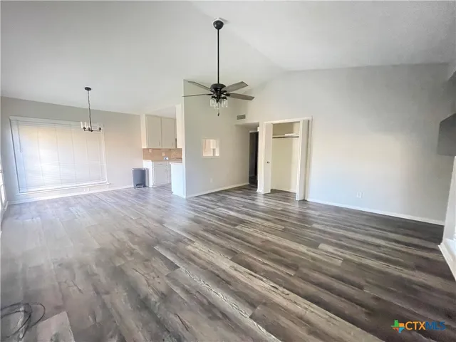 a view of a livingroom with a ceiling fan wooden floor and a ceiling fan