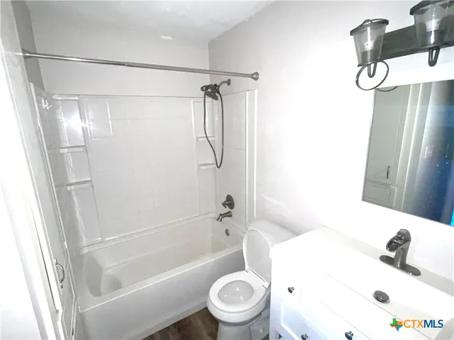 a bathroom with a shower a toilet and a sink