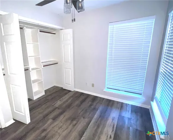 a view of empty room with wooden floor and window