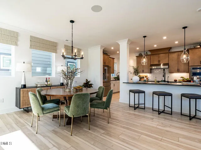 a dining room with stainless steel appliances kitchen island granite countertop a dining table chairs and a kitchen view