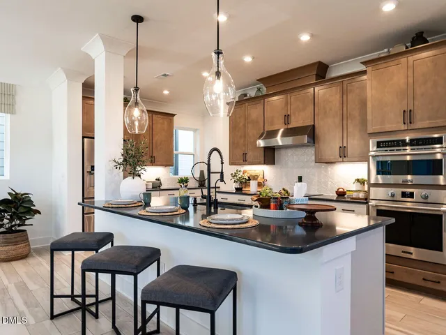 a kitchen with sink a stove and chairs