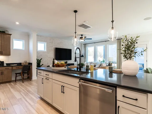 a kitchen with sink and view of living room