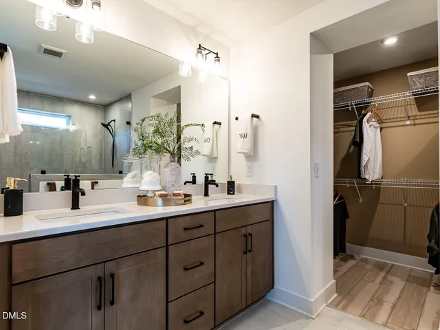 a bathroom with a double vanity sink a mirror and shower