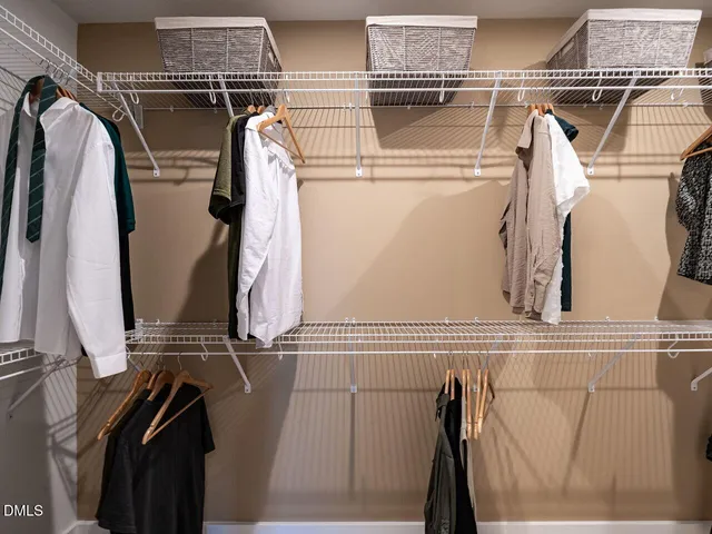 a view of walk in closet with clothes and shoes