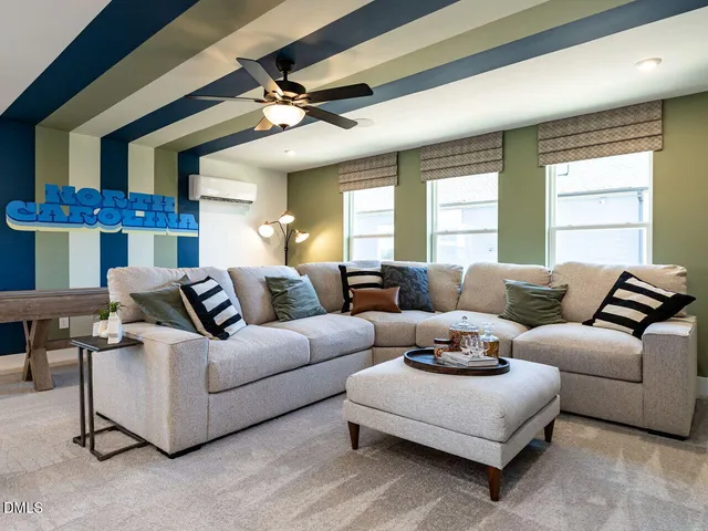 a living room with furniture and a ceiling fan