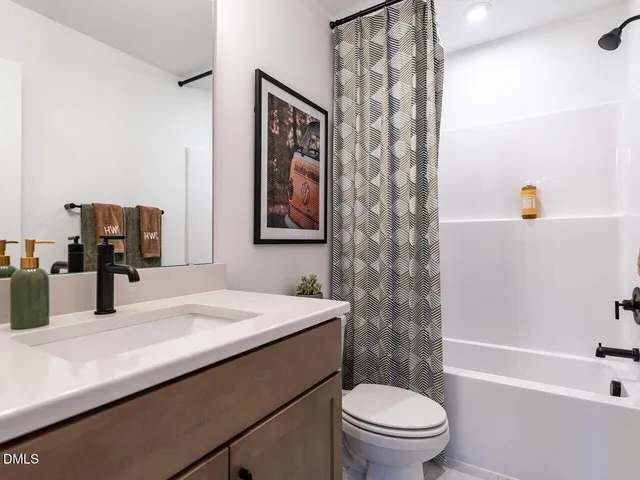 a bathroom with a sink a toilet and shower curtain