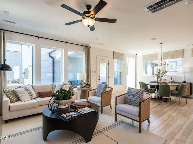 a living room with furniture ceiling fan and a large window