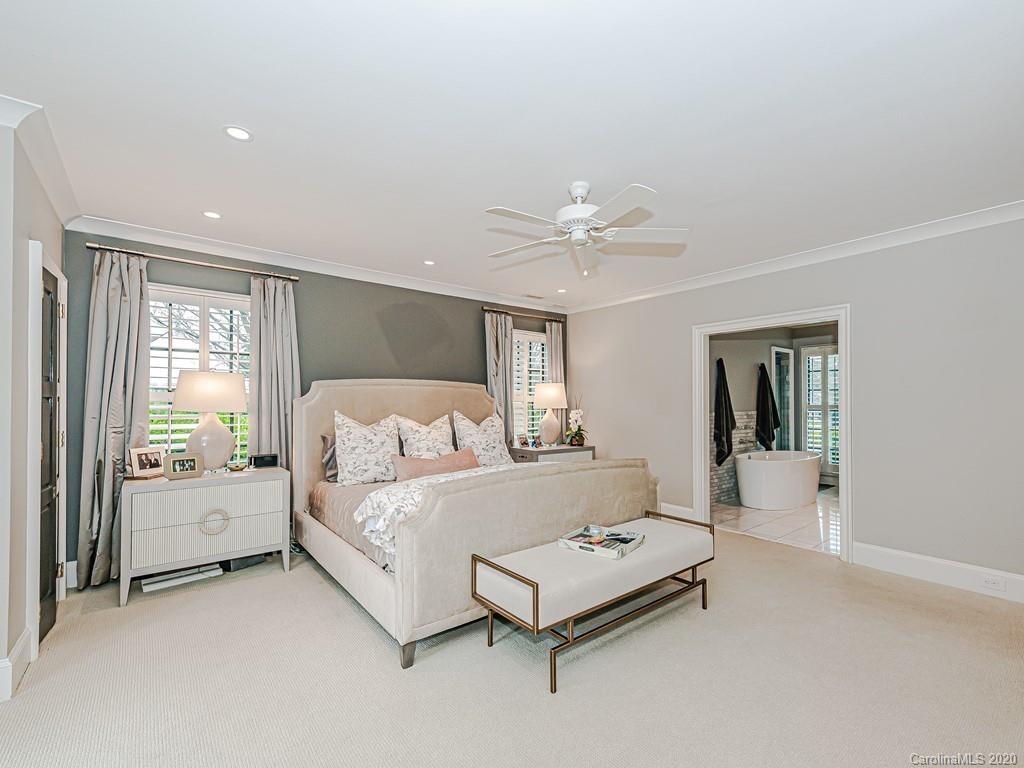 3429 Sharon Road Charlotte, NC 28211 - Photo 26 of 48 a bedroom with a bed and a chandelier