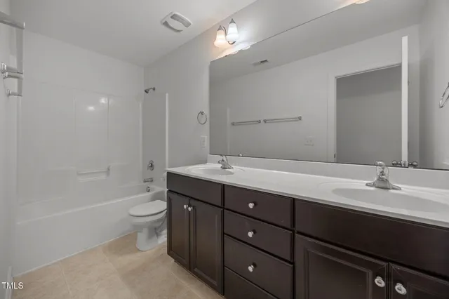 a bathroom with a sink double vanity granite tub and a mirror