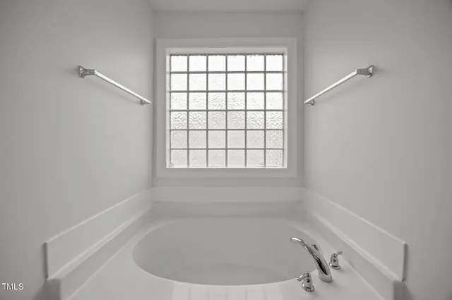 a bath tub sitting in a bathroom next to a window