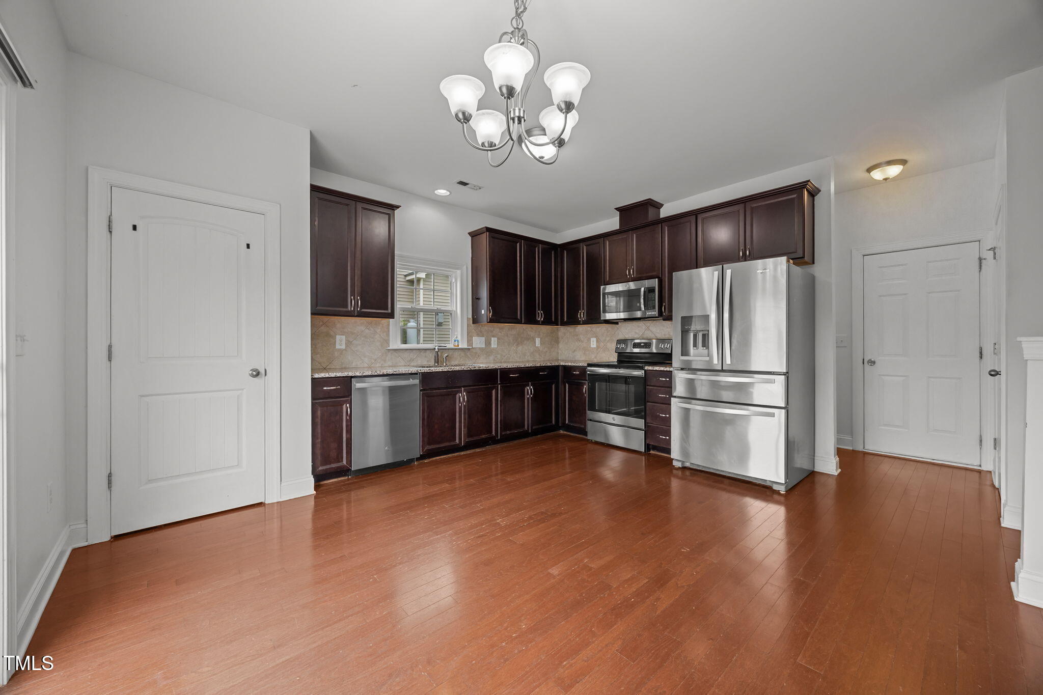 88 Arbor Loop Angier, NC 27501 - Photo 6 of 36 a kitchen with stainless steel appliances wooden floor and a refrigerator