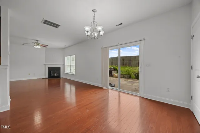 a view of a livingroom with wooden floor fireplace and windows